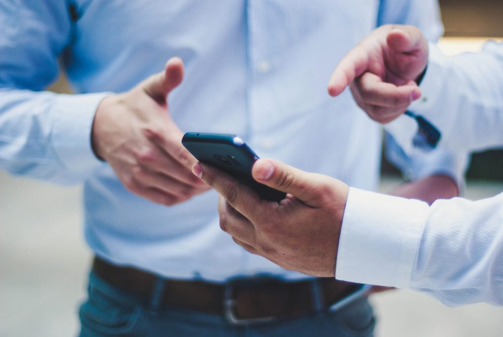Zwei Männer diskutieren über Smartphone