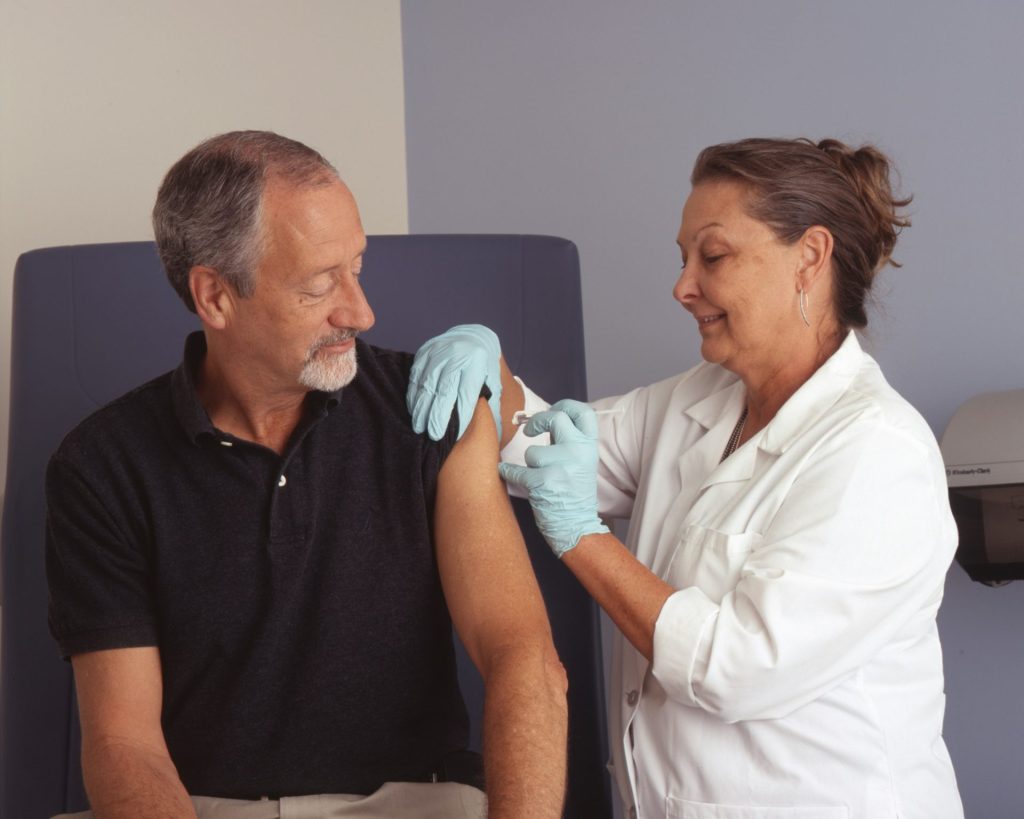 Arzt impft männlichen Patienten